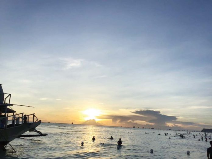 Tourists enjoy the beach and the sunset in Boracay Island.