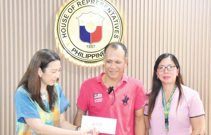 ime-honest-cabbie-1 Dr. Kathy Fermin-Gorriceta personally hands over a P30,000 cash reward from Iloilo 2nd District’s Cong. Michael Gorriceta to taxi driver Anthony Aguirre of Barangay Amparo, Pavia, Iloilo, who returned P2.4 million in cash left by his passenger. Joining Aguirre at the congressman’s office is A&A Marie Taxi operator Aldrina Janobas. PHOTO FROM CONG. MICHAEL GORRICETA’S FACEBOOK PAGE