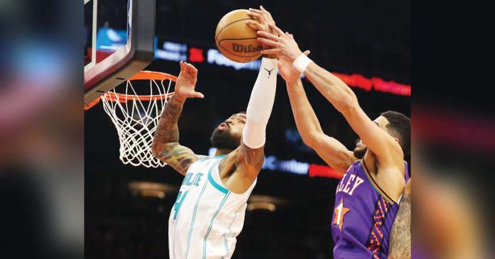 sports-Phoenix-1_superimposed Nick Richards, then of Charlotte Hornets, grabs the rebound away from Phoenix Suns guard Devin Booker during the second half of their January 12 game at Footprint Center in Phoenix, Arizona. Photo courtesy of Mark J. Rebilas-Imagn Images