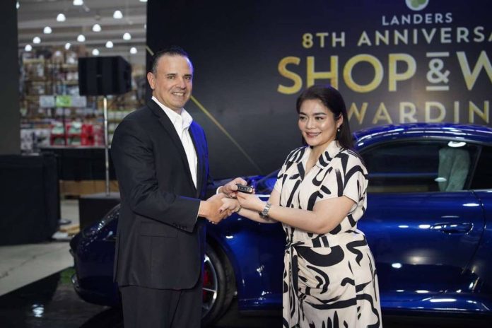1 Landers Superstore Chief Transformation Officer Bill Cummings turns over the key to a brand-new Porsche 911 Carrera S to Ms. Ingrid Rose Panuncialman, a lucky winner from Landers Alabang, during the Grand Shop & Win Raffle Awarding Ceremony.