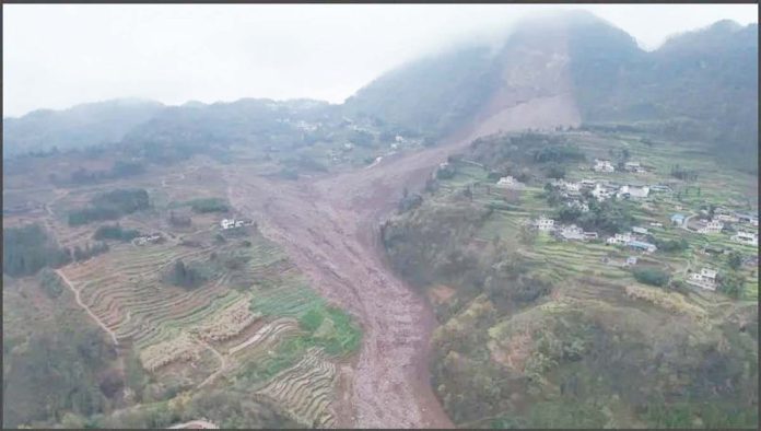 China-1 An aerial shot shows the damage after a landslide in south-western China. A large brown slash of mud and rock cuts through the otherwise green landscape in Jinping village in Sichuan province. XINHUA/AP