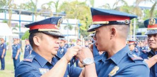 Brigadier General Jack Wanky, director of the Police Regional Office 6, administers the simultaneous oath-taking, donning, and pinning of ranks of the newly promoted officers on Thursday, Feb. 6, 2025. PRO-6 PHOTO