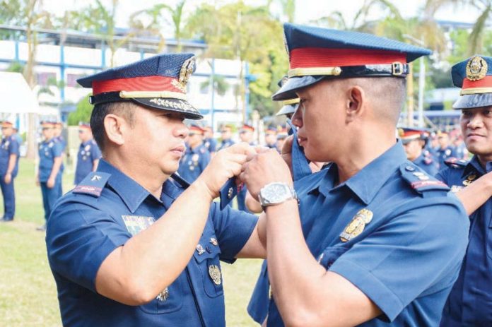 cops_promoted1_resized Brigadier General Jack Wanky, director of the Police Regional Office 6, administers the simultaneous oath-taking, donning, and pinning of ranks of the newly promoted officers on Thursday, Feb. 6, 2025. PRO-6 PHOTO