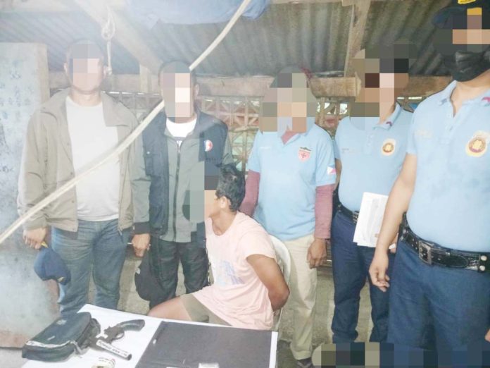 drug-suspect-1jpg Alias “Bebot” (sitting) was caught with suspected shabu and a 12-gauge shotgun in a raid in Calinog, Iloilo on Monday morning, Feb. 10, 2025. CALINOG MUNICIPAL POLICE STATION PHOTO