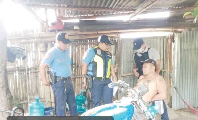 Iloilo Province’s No. 3 most wanted man, Romy Porras Pancrudo (sitting), was arrested on Wednesday, Feb. 25, 2025, in Cabatuan town. CABATUAN MPS PHOTO