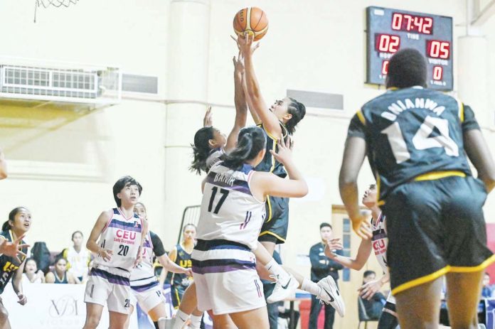 sports_UST_resized Kent Jane Pastrana of the University of Santo Tomas Growling Tigresses scores against a Centro Escolar University Scorpions defenders. WMPBL PHOTO