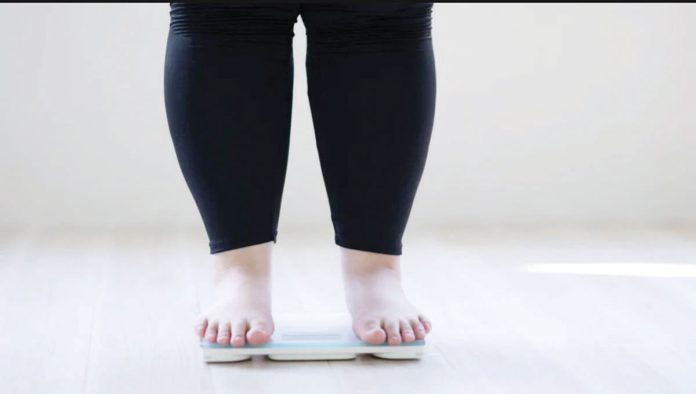 UK_1_resized Researchers warn that obesity levels are predicted to accelerate rapidly during the remainder of this decade, particularly in lower-income countries. Photo shows a woman who is overweight standiing on a weighing scale. GETTY IMAGES