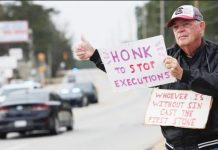 Double murderer is first US inmate executed by firing squad in 15 years An anti-death penalty protester holds signs in South Carolina, USA.