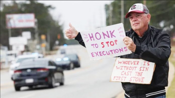 US-1 An anti-death penalty protester holds signs in South Carolina, USA.