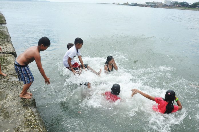 front_pic_resized COOLING OFF IN OPEN AIR. Children cool off by jumping into the waters along the breakwater in Barangay Pala-pala, Iloilo City, enjoying a splash of relief amid the soaring temperatures. As the heat continues to rise across Western Visayas, these young ones make the most of the cooling coastal waters. PN
