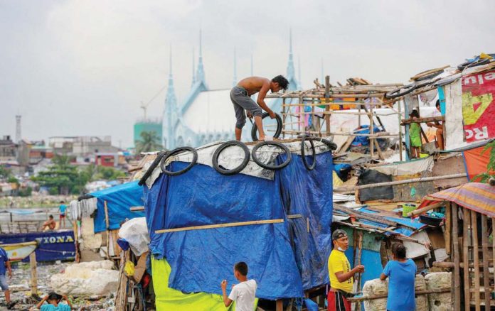 hunger_1_resized A Social Weather Stations survey showed that families in Visayas were the hardest hit by hunger at 33.7 percent, followed by Metro Manila at 28.3 percent in March 2025. Photo shows a resident uses plastic sacks and scrap wood as he strengthens a shanty to help make it withstand the storms in Baseco Community in Tondo, Manila. JONATHAN CELLONA/ABS-CBN NEWS FILE PHOTO