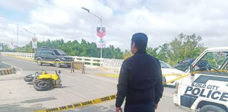 A police officer secures the spot where motorcycle-driving businessman Delfin Britanico was shot to death in Barangay Nabitasan, La Paz, Iloilo City on Jan. 19. 2020. PN FILE
