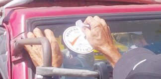 A Bacolod Traffic and Transportation Management Department (BTTMD) officer applies a road safety sticker on a public utility jeepney as part of the ongoing effort to prepare Bacolod City for the phase-out of older jeepneys under the Public Utility Vehicle Modernization Program.