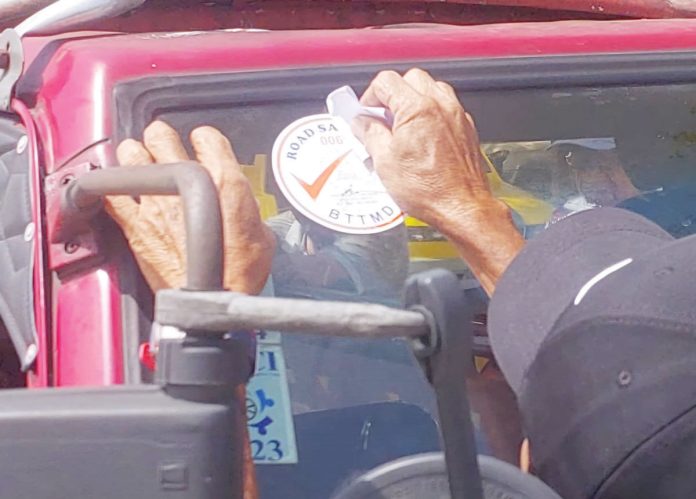 mae_traffic_resized A Bacolod Traffic and Transportation Management Department (BTTMD) officer applies a road safety sticker on a public utility jeepney as part of the ongoing effort to prepare Bacolod City for the phase-out of older jeepneys under the Public Utility Vehicle Modernization Program.