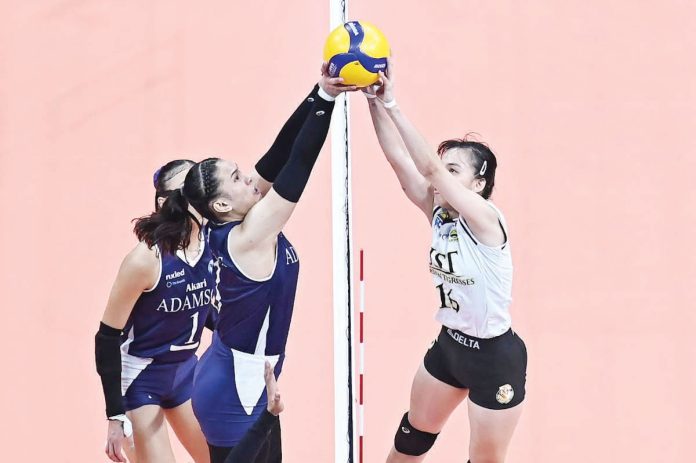 spors_UST_1_resized Negrense Cassie Carballo of the University of Santo Tomas Golden Tigresses and Jen Villegas of the Adamson University Lady Bulldogs joust for the ball on top of the net. UAAP PHOTO