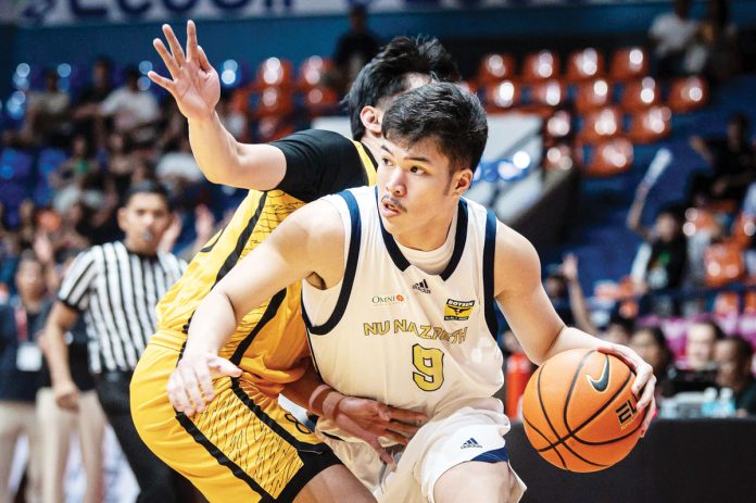 sports-NUNS Ilonggo Chad Cartel of the National University Nazareth School Bullpups tries to ward off a University of Santo Tomas Tiger Cubs' defender. UAAP PHOTO