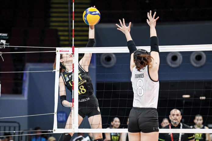 sports_UST_resized University of Santo Tomas Golden Tigresses’ Regina Jurado avoids the defense of Bacolodnon Joan Marie Monares of the University of the Philippines Fighting Maroons for a drop ball. UAAP PHOTO