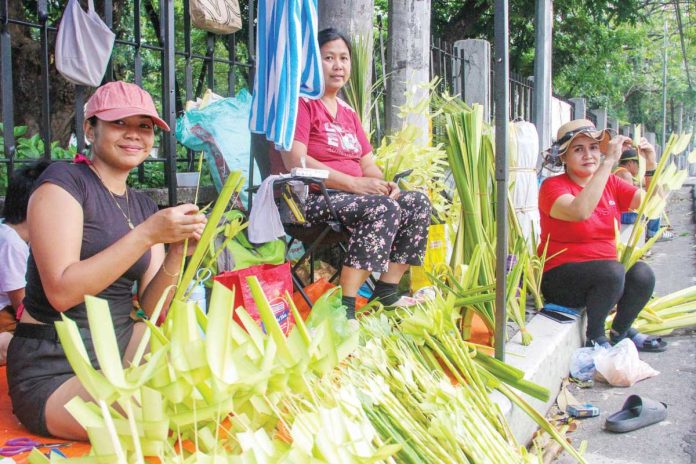 PBBM_1_resized These women from Laguna province make palaspas (woven palm leaves) for Palm Sunday in front of the Diocesan Shrine of Jesus the Divine Word in E. Rodriguez Sr. Avenue, Quezon City. They say the business has been passed down through generations since the 1980s. PNA