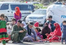 Pakistan expels tens of thousands of Afghans A scene at the Torkham crossing showing men, women and children sitting on the floor. There are several vehicles in the background. GETTY IMAGES