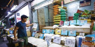 A store owner sorts out his rice products at Kamuning Public Market in Quezon City. Malacañang has urged farmers to seek local government units’ assistance in directly selling their palay (unhusked rice) to the National Food Authority, which buys the dry variety for P23 to P24 per kg.