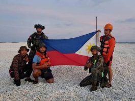 Personnel from the Philippine Navy, Philippine Coast Guard, and the Philippine National Police Maritime Group raise the Philippine flag on Pag-asa Cay during a maritime operation on April 27, 2025. PHOTO FROM THE NATIONAL TASK FORCE-WEST PHILIPPINE SEA