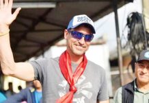 Kenton Cool, in a trucker cap and grey T-shirt, waves upon arriving at the airport in Kathmandu, Nepal on May 19, 2023, after he reached the top of Everest for the 17th time. He has achieved the feat twice more as of May 18, 2025. GETTY IMAGES