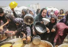 Displaced Palestinians gather to receive a portion of food from a charity kitchen, in Jabalia refugee camp, northern Gaza. EPA/SHUTTERSTOCK