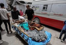 An injured man is pictured outdoors on a bed on wheels. He will be transported to the Kamal Adwan Hospital in the Gaza Strip. GETTY IMAGES