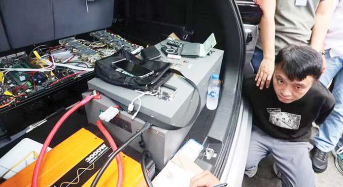 Palace-alarmed Agents of the National Bureau of Investigation secure Tak Hoi Lao, 48, who is caught allegedly carrying a phone eavesdropping device in Intramuros, Manila, on Tuesday. MARIANNE BERMUDEZ, PHILIPPINE DAILY INQUIRER