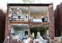 The back of a two-storey house is completely exposed after a tornado completely tore off the back wall in St. Louis, Missouri, on May 16, 2025. Two residents can be seen in an upper room, one with a broom in her hands. REUTERS