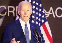 Former United States President Joe Biden stands in front of several American flags and speaks into a cluster of microphones during the Advocates, Counselors, and Representatives for the Disabled bipartisan conference in Chicago. GETTY IMAGES