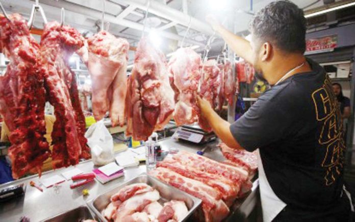 economist_on_inflation_resized A butcher arranges various pork meat cuts at a stall inside the Arranque Market in Sta. Cruz, Manila on March 10, 2025. Rizal Commercial Banking Corporation chief economist Michael Ricafort on Thursday, May 1, 2025, said imposition of a maximum suggested retail price on rice and pork helped eased rice and pork prices. PNA PHOTO BY YANCY LIM