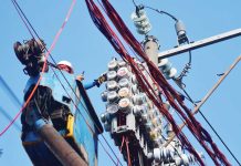 Workers inspect an electric meter installed above ground in Manila on January 11, 2024. MARK DEMAYO, ABS-CBN NEWS/FILE
