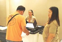 A resident of Barangay Airport, Mandurriao, Iloilo City participates in the final testing and sealing of vote counting machines at Festive Walk Mall on May 5, supervised by members of the Electoral Board ahead of the May 12 elections. AJ PALCULLO/PN