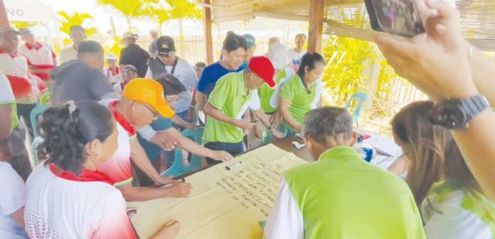 neljoy-pan-de-azucar Barangay leaders from Tambaliza, Talotoan, and Macatunao in Pan de Azucar Island sign a pledge of commitment during a consultative meeting held on May 5, 2025, in Barangay Tambaliza, Concepcion, Iloilo. The activity forms part of the Iloilo Provincial Government’s efforts to unify local stakeholders in support of the proposed declaration of Pan de Azucar Island as an eco-tourism destination. SCREEN GRAB/SCREENSHOT FROM BALITA HALIN SA KAPITOLYO