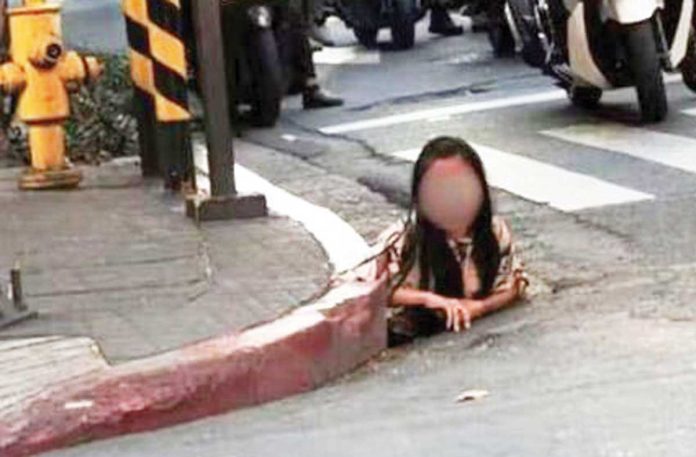 A woman is seen crawling out of a Makati City sewer at the corner of Rufino and Adelantado Streets in Salcedo Village, Barangay Bel-Air on May 26, 2025. PHOTO FROM ROUGHMASTERPIECEI/REDDIT