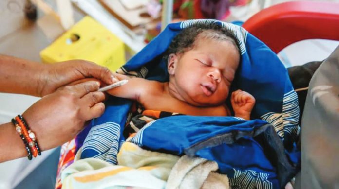 London A young baby wrapped in blanket receives a vaccination in Senegal. GETTY IMAGES