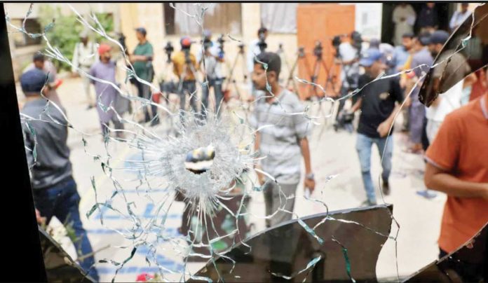 Pakistan_copy_resized Men in plain clothes and some in police uniform are seen through a broken jail glass window with a hole created by some sort of impact in Pakistan. Inmates broke down doors and locks of their cells and shattered windows before storming the prison gates. REUTERS