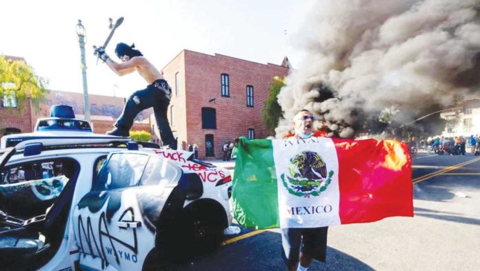 US_resized A demonstrator hits a Waymo self-driving car with his skateboard during a protest against federal immigration sweeps in downtown Los Angeles on June 8. REUTERS