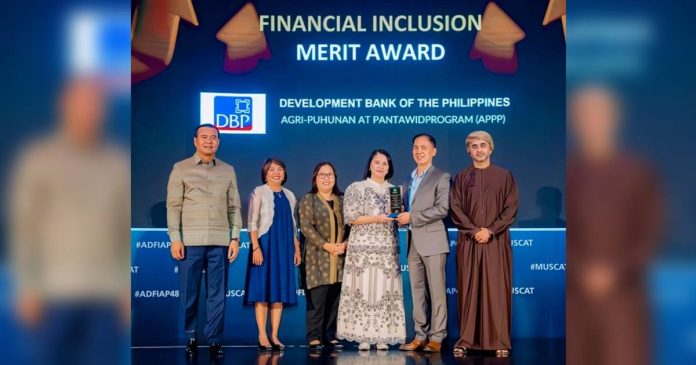 dbp DBP Senior Vice President Ronaldo U. Tepora (second from right) and Senior Vice President Catherine T. Magana (third from right) receive the Merit Award for Financial Inclusion conferred to DBP for its participation in DA’s Agri-Puhunan at Pantawid Program (APP) during the 48th ADFIAP Annual Meeting in Muscat, Oman. Also in photo are (from left): Agricultural and Rural Development Bank Chief Executive Officer Dr. KAO Thach, DBP First Vice President Atty. Ma. Cristina C. Malab, DBP Senior Vice President Soraya F. Adiong and Development Bank in Sultanate of Oman Chief Executive Officer Mr. Hussain Al Lawati.