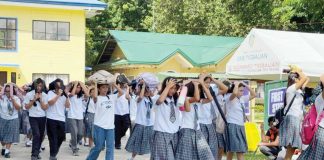 Students of Tigbauan National High School cover their heads with bags and books as they evacuate to safety during the simulated magnitude 7.2 earthquake, held under the 2nd Quarter Nationwide Simultaneous Earthquake Drill in Tigbauan, Iloilo. PHOTO FROM CIVIL DEFENSE WESTERN VISAYAS FACEBOOK
