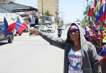 With flags in hand and resilience in her eyes, vendor Jane waves at passing vehicles along a busy Iloilo City street. Despite dwindling interest, she keeps the tradition alive — one flag, one hopeful gesture at a time.