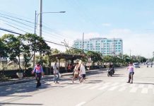 Pedestrians cross a designated lane along the Sen. Benigno Aquino Sr. Avenue near in Barangay Ungka, Jaro, Iloilo City — one of several areas under scrutiny as the city reviews the safety, placement, and visibility of crosswalks following a fatal road incident involving a student. ICTTMO Photo