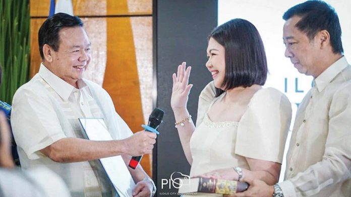 mai-raisa-oath-copy Iloilo City’s Mayor-elect Raisa Treñas-Chu takes her oath of office, with husband Francis by her side and father Mayor Jerry Treñas holding the microphone for her. Regional Trial Court Executive Judge Rose Edith Togonon (not in photo) administered Treñas-Chu’s oath. ILOILO CITY PIO PHOTO
