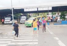 A traffic aide assists pedestrians at a busy Iloilo City transport terminal ahead of today’s June 16 class opening, as authorities brace for increased foot and vehicle traffic with the return of students. ICTTMO PHOTO