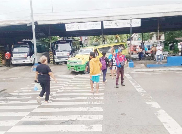 mai-traffic A traffic aide assists pedestrians at a busy Iloilo City transport terminal ahead of today’s June 16 class opening, as authorities brace for increased foot and vehicle traffic with the return of students. ICTTMO PHOTO