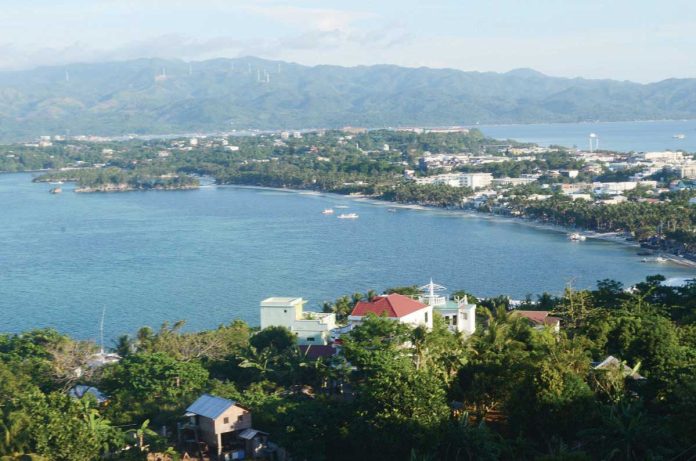 This is an elevated view of Bulabog Beach as seen from the Mt. Luho View Deck in Barangay Yapak, Boracay Island. The proposed construction of a bridge linking Boracay to mainland Aklan (which can be seen in the background) has drawn strong opposition from the island’s Ati community, who fear that such development threatens their ancestral domain, traditional livelihoods, and cultural identity. PN FILE
