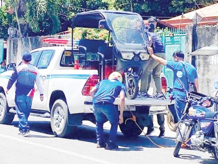 mai_colorum_copy_resized Traffic enforcers load an unregistered e-trike onto a government vehicle during the first day of the crackdown on colorum tricycles in Barangay South Baluarte, Molo, Iloilo City. ILOILO CITY GOVERNMENT PHOTO