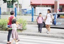 Parents and guardians escort schoolchildren across a pedestrian lane near a public elementary school in Iloilo City during the first day of classes on June 16, 2025. Authorities reported a safe and orderly school opening across Western Visayas. AJ PALCULLO/PN