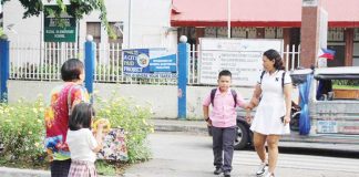 Parents and guardians escort schoolchildren across a pedestrian lane near a public elementary school in Iloilo City during the first day of classes on June 16, 2025. Authorities reported a safe and orderly school opening across Western Visayas. AJ PALCULLO/PN